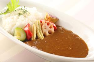 a white bowl of food with rice and sauce at Hotel Quest Shimizu in Shizuoka