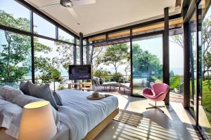 een slaapkamer met een bed en grote ramen bij The View in Taling Ngam Beach