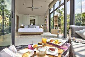 een slaapkamer met een bed en een tafel met eten erop bij The View in Taling Ngam Beach