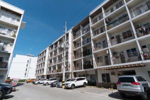 a parking lot with cars parked in front of a building at RedDoorz at Kassel Residences Parañaque in Manila