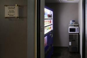 a refrigerator in a room with a microwave at Hotel Quest Shimizu in Shizuoka