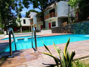 a swimming pool in front of a house at Hotel Sierra Linda in Xilitla