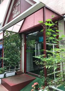 une porte d'entrée d'un bâtiment avec des plantes dans l'établissement Ari House, à Séoul