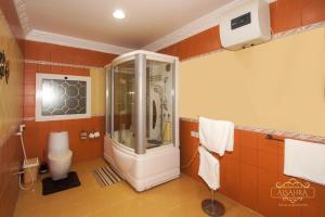 een badkamer met douche en toilet bij ALSAHRA Belshamal Hotel in Rafha