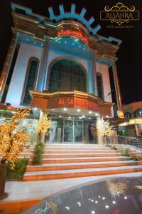 een gebouw met een trap voor een gebouw bij ALSAHRA Belshamal Hotel in Rafha