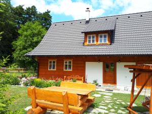 a wooden house with a picnic table in front of it at Chalupa Pomněnka in Komorní Lhotka