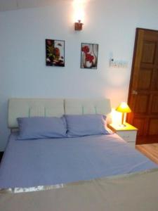 a bedroom with a large bed with blue pillows at Happy Sweet Residence in Melaka