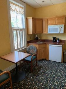 a kitchen with wooden cabinets and a table and a table at Original Springs Hotel in Okawville