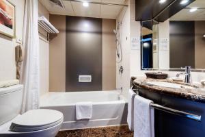 a bathroom with a tub and a toilet and a sink at Grand Park Kunming in Kunming