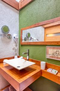 baño con lavabo blanco y pared verde en La Joya del Viento, en Valle de Bravo