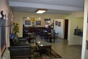 ein Restaurant mit Sofa und Tischen und eine Bar in der Unterkunft Days Inn & Suites by Wyndham Des Moines Airport in Des Moines