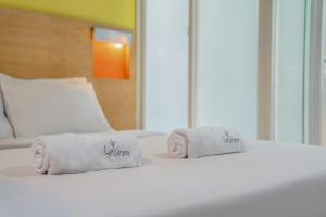 1 dormitorio con 2 toallas en una cama en LeGreen Suite Poso, en Yakarta