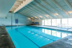 a swimming pool with blue water in a building at Birch Bay waterfront 2 bedroom condo - Lofted layout & steps from beach in Blaine