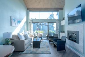 a living room with a couch and a fireplace at Birch Bay waterfront condo - Lofted layout & steps from beach in Blaine