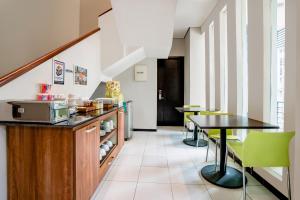 a kitchen with a table and green chairs at LeGreen Suite Setiabudi in Jakarta