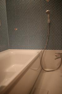 ein Badezimmer mit einer Badewanne mit einem Schlauch in der Unterkunft 無鹿リゾート in Kokuryō