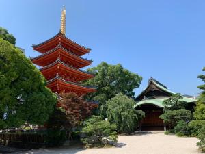 una gran pagoda roja frente a un edificio en TRIP POD TSUMASHOJI, en Fukuoka
