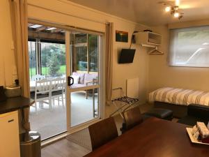 a room with a dining table and a sliding glass door at Angie's Rural Retreat in Wainuiomata