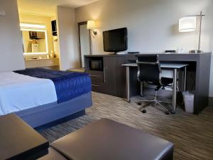 a hotel room with a bed and a desk and a tv at Best Western Dickson in Dickson