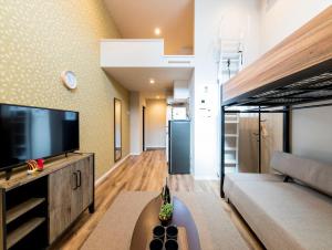 een woonkamer met een grote flatscreen-tv bij TRIP POD CHIYO A in Fukuoka