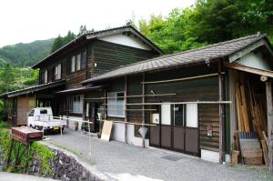 a wooden house with a truck parked in front of it at Guesthouse Kamikoya ゲストハウス かみこや in Yusuhara