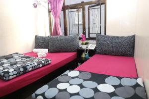 Duas camas num quarto cor-de-rosa e preto em Icon Inn em Hong Kong