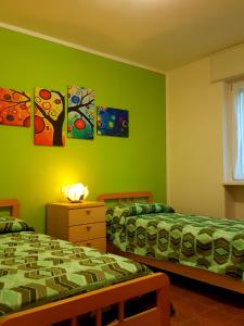 two beds in a room with green walls at Appartamento la Canvetta in Santa Maria Maggiore