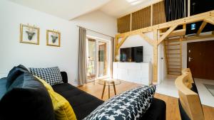 ein Wohnzimmer mit Sofa und Fernseher in der Unterkunft Apartamenty EverySky - Emilii Plater 18-18A in Karpacz