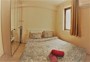 een slaapkamer met een bed met een rood kussen erop bij Charming beach 2 room flat in Haifa