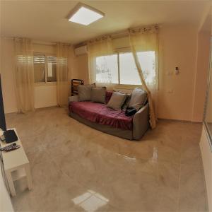 salon z kanapą i oknem w obiekcie Charming beach 2 room flat w mieście Hajfa