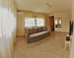 salon z kanapą i telewizorem w obiekcie Charming beach 2 room flat w mieście Hajfa