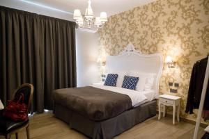 - une chambre avec un lit blanc et des oreillers bleus dans l'établissement BB De Rohan, à Żebbuġ
