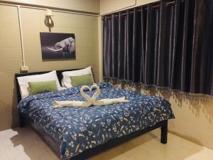 a bedroom with a bed with two swans on it at Nett Hotel in Lop Buri
