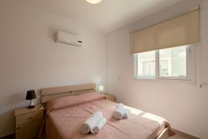 a bedroom with a bed with two towels on it at Oceania Bay Village in Pyla
