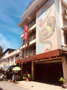 a building with a painting of a rooster on it at Nett Hotel in Lop Buri