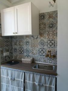 a kitchen with a sink and some tiles on the wall at Il Castello in Casamassima