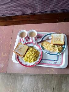 a tray of breakfast food with eggs and toast at Kitsel Homestay in Ravangla