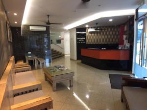 a restaurant with benches and a table in a room at Padungan Hotel in Kuching