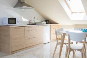 a kitchen with wooden cabinets and a table with chairs at Willa Boconek - Zator Przeciszów in Zator