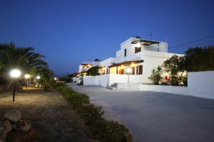 a white building at night with a street light at Galini in Agia Irini Milos