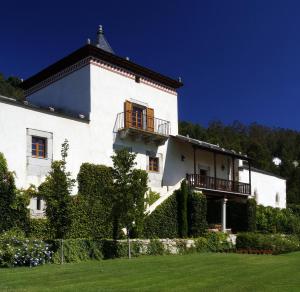 a white building with a balcony on top of it at Hotel Rural Palacio de Prelo in Boal
