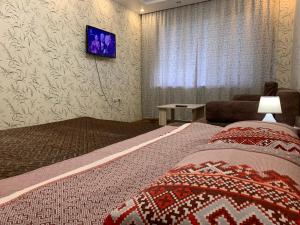 アンガルスクにあるАпартаменты LUX в центреのベッドルーム1室(ベッド2台、壁掛けテレビ付)