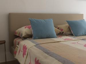 a bed with two blue pillows on top of it at casa gramazio in Manfredonia