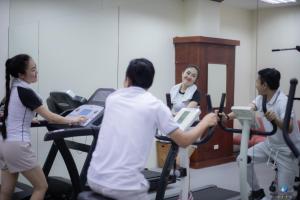 a group of people riding on exercise bikes in a gym at Vientiane Plaza Hotel in Vientiane