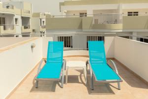 two blue chairs and a table on a balcony at Oceania Bay Village in Pyla