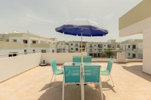 a table and chairs with an umbrella on a balcony at Oceania Bay Village in Pyla