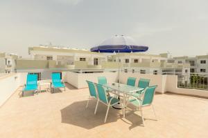 a patio with a table and chairs and an umbrella at Oceania Bay Village in Pyla