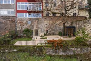 un ancien bâtiment en briques avec une porte et une clôture dans l'établissement Castle Apartments Budapest, à Budapest