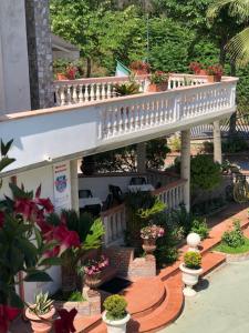 a garden with potted plants and a white staircase at B&B Primerano SP73 in Soriano Calabro
