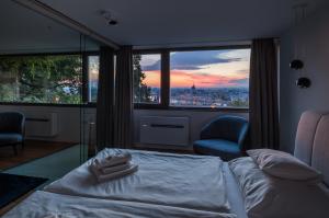 sypialnia z łóżkiem, 2 krzesłami i oknem w obiekcie Castle Apartments Budapest w Budapeszcie